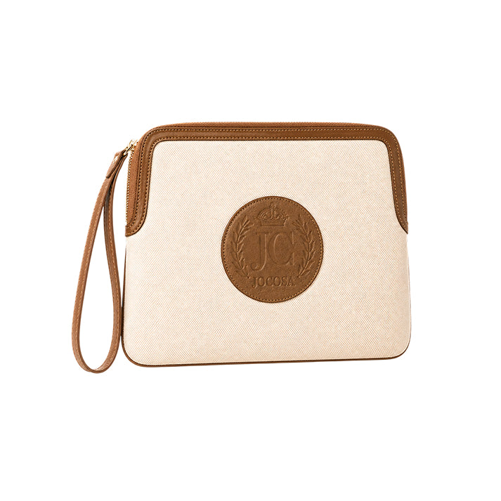Three-quarter front view of the JOCOSA Locker Pouch in ivory canvas with camel leather trim, embossed leather logo, gold-tone zipper and matching wrist strap.
