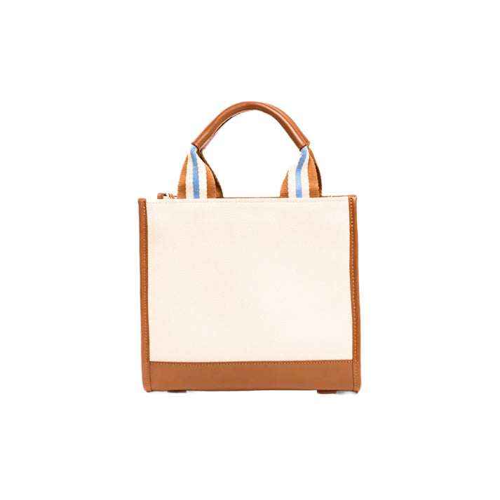 Back view of the JOCOSA Club Tote in ivory canvas with camel leather trim, camel, ivory and blue striped handles, reinforced leather base and structured rectangular silhouette.