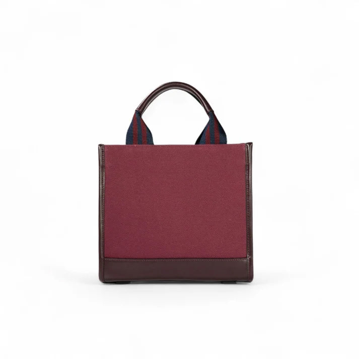Back view of the JOCOSA Club Tote in bordeaux canvas with bordeaux leather trim, navy and bordeaux striped handles, reinforced leather base and structured rectangular silhouette.