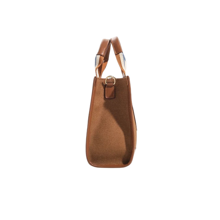 Side view of the JOCOSA Club Tote bag in camel canvas with camel leather trim, camel, ivory and blue striped handles and gold-tone hardware.